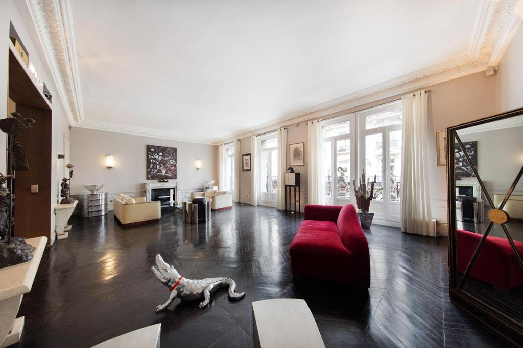 Grand salon haussmannien du Loft Triangle d'Or — parquet à chevrons, moulures d'époque, art contemporain